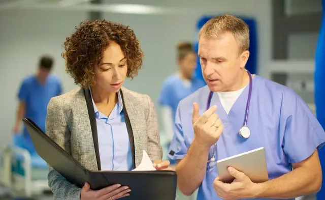 Nursing administrator reviewing patient diagnosis and treatment with registered nurse